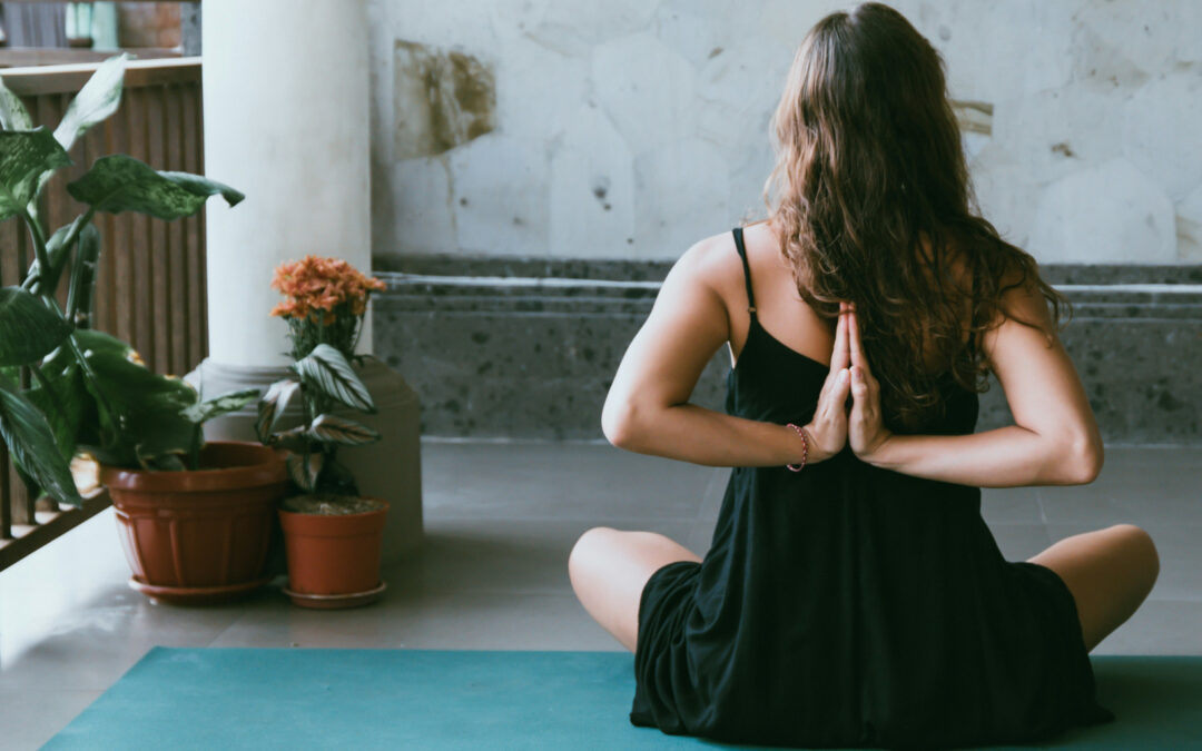 Una donna di schiena che fa esercizi di Yoga.