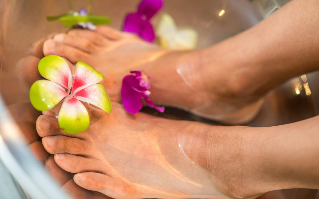 Piedi dentro un vaso di oli caldi con dei fiori intorno