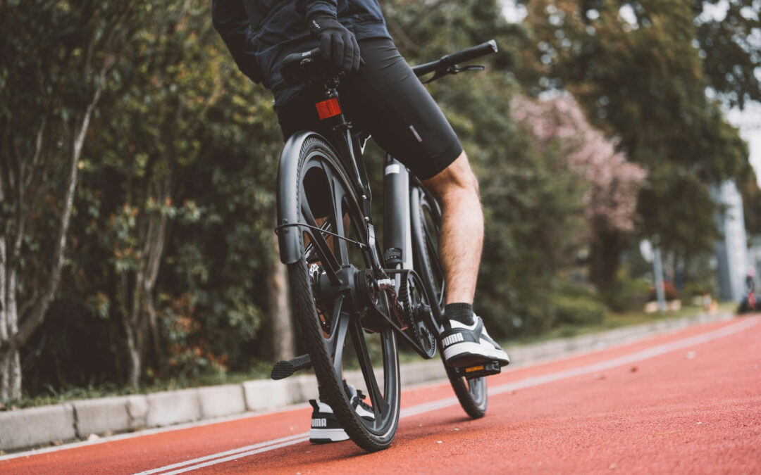 Un uomo in sella a una bicicletta su una pista ciclabile.